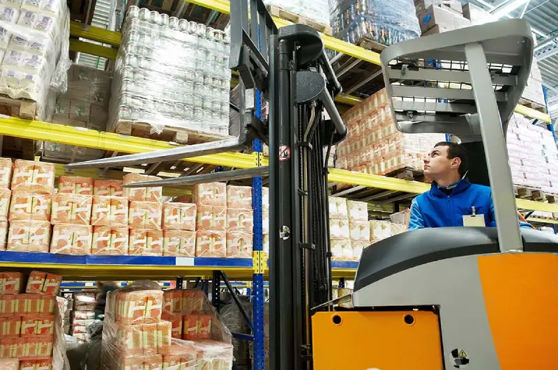 Warehouse worker operating forklift for picking and packing operations in distribution center